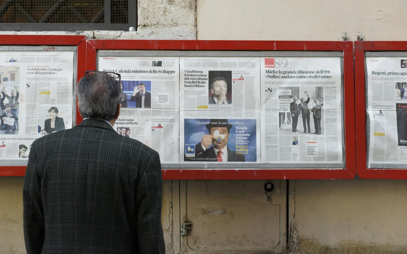 man reading newspaper in bulletin board by Filip Mishevski courtesy of Unsplash.