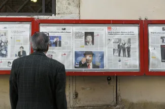 man reading newspaper in bulletin board by Filip Mishevski courtesy of Unsplash.