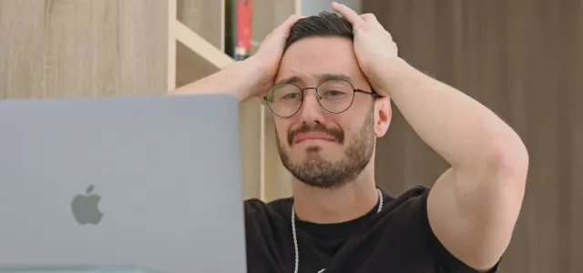 a man with glasses is looking at a laptop by Francisco De Legarreta C. courtesy of Unsplash.